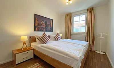 Schlafzimmer mit Doppelbett (1,80 m x 2,00 m), Nachttischablagen und einem großen Kleiderschrank