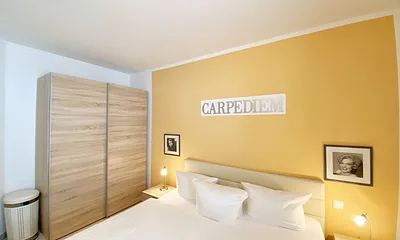 Schlafzimmer mit Doppelbett (1,80 m x 2,00 m), Nachttischablagen mit Beleuchtung, Kleiderschrank und einem Spiegel