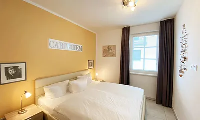 Schlafzimmer mit Doppelbett (1,80 m x 2,00 m), Nachttischablagen mit Beleuchtung, Kleiderschrank und einem Spiegel