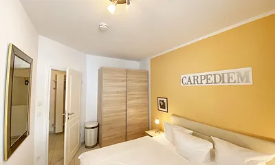 Schlafzimmer mit Doppelbett (1,80 m x 2,00 m), Nachttischablagen mit Beleuchtung, Kleiderschrank und einem Spiegel