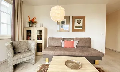 Wohnbereich mit Couch (Aufbettungsmöglichkeit für die 3. Person, 1,60 m x 2,00 m), Couchtisch, Sessel, Vitrine, TV-Board mit Flachbild-TV, Musikanlage mit CD-Player und Radio