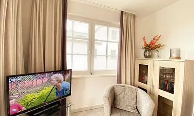 Wohnbereich mit Couch (Aufbettungsmöglichkeit für die 3. Person, 1,60 m x 2,00 m), Couchtisch, Sessel, Vitrine, TV-Board mit Flachbild-TV, Musikanlage mit CD-Player und Radio