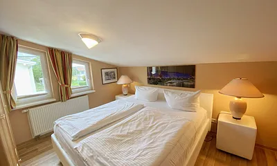 großes Schlafzimmer mit Doppelbett (1,80 m x 2,00 m), Nachttischablagen und Beleuchtung, Kleiderschrank, Sideboard sowie ein TV
