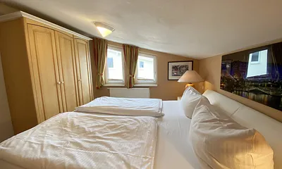 großes Schlafzimmer mit Doppelbett (1,80 m x 2,00 m), Nachttischablagen und Beleuchtung, Kleiderschrank, Sideboard sowie ein TV