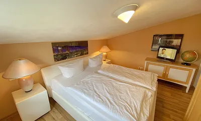 großes Schlafzimmer mit Doppelbett (1,80 m x 2,00 m), Nachttischablagen und Beleuchtung, Kleiderschrank, Sideboard sowie ein TV