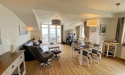 Wohnbereich mit bequemer Ledercouch, Lesesessel mit Hocker, Couchtisch, TV-Board mit Flachbild-TV, Musikanlage und Urlaubslektüre 