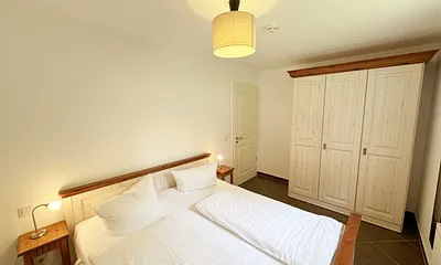 Schlafzimmer mit Doppelbett und Kleiderschrank