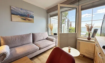 Wohnzimmer mit gemütlicher Couch und Seeblick