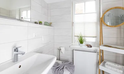 Tageslicht-Bad mit ebenerdiger Dusche, WC, Fön sowie ein Waschplatz mit dazugehörigem Spiegel