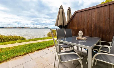 sonnige und bestuhlte Terrasse (Süd) mit Sonnenschirm und Seeblick