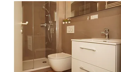 innenliegendes Badezimmer mit Dusche, WC, Fön sowie ein Waschplatz mit dazugehörigem Spiegel