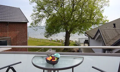 bestuhlter Balkon (Süd) mit Sonnenschirm und Seeblick