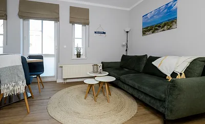 komfortabler Wohnbereich mit einer Schlafcouch (Aufbettungsmöglichkeit, 1,40 m x 1,90 m), Couchtisch, Stehlampe sowie eine Kommode mit Flachbild-TV