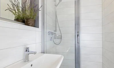 innenliegendes Badezimmer mit Dusche, WC, Fön sowie ein Waschplatz mit dazugehörigem Spiegel