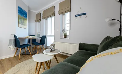 komfortabler Wohnbereich mit einer Schlafcouch (Aufbettungsmöglichkeit, 1,40 m x 1,90 m), Couchtisch, Stehlampe sowie eine Kommode mit Flachbild-TV