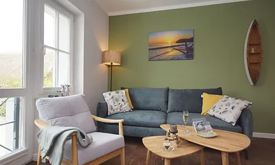 komfortabler Wohnbereich mit einer Couch (Aufbettungsmöglichkeit 1,40m x 1,90m), Couchtisch, Sessel, Stehlampe sowie eine Kommode mit Flachbild-TV 