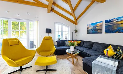 Wohnbereich mit einer Wohnlandschaft (Aufbettungsmöglichkeit für 5./6. Person), Couchtisch, 2 Relaxsessel, 2 Stehlampen, einen Kamin (Holz inklusive) sowie eine TV-Bank mit Flachbild-TV 