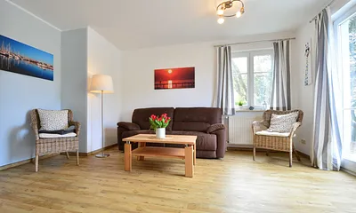 Der offene Wohnbereich mit Zugang zur möblierten West-Terrasse