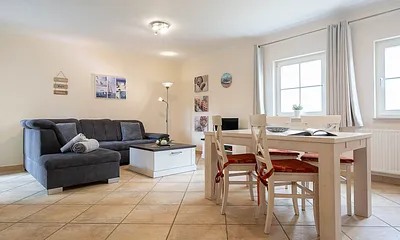 Der Wohnbereich mit gemütlicher Couchgarnitur und Esstisch