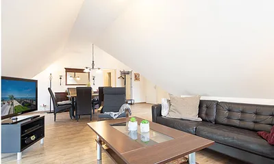 Der gemütliche Wohnbereich mit Couchgarnitur und großem Flachbild-TV