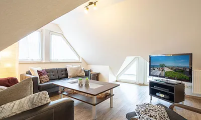 Der gemütliche Wohnbereich mit Couchgarnitur und großem Flachbild-TV