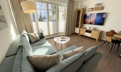 Wohnbereich mit Schlafcouch (Aufbettung für 2 Personen, 1,30 m x 2,00 m), Couchtisch, TV-Board, Smart-LED-TV, Blu-Ray-Player, Mini-Stereo-Anlage mit Bluetooth und USB-Anschluss inkl. Internet-Radio 