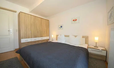 Schlafzimmer mit Doppelbett (1,80 m x 2,00 m), Nachttischkonsolen, großem Kleiderschrank und Insektenschutz