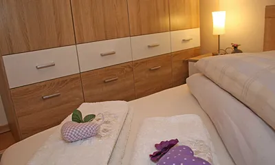 Schlafzimmer mit Doppelbett (1,80 m x 2,00 m), Nachttischkonsolen, großem Kleiderschrank und Insektenschutz
