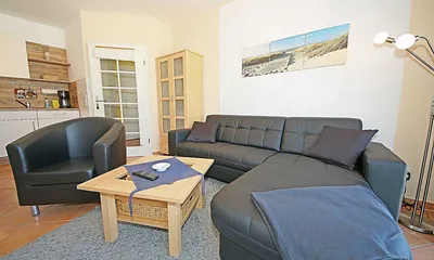Wohnbereich mit gemütlicher Ledereckcouch (Aufbettung für 3. Person 1,10 m x 1,90 m), Sessel, Tisch, Sideboard, Smart-TV, DAB-Radio und Leselampe