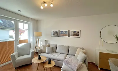 Wohnbereich mit moderner Couch mit Ottomane (1,40 m x 2,00 m), Flachbild-TV, DAB–Radio, DVD-Player, Sessel und Stehlampe