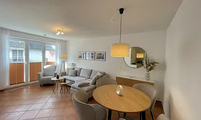 Wohnbereich mit moderner Couch mit Ottomane (1,40 m x 2,00 m), Flachbild-TV, DAB–Radio, DVD-Player, Sessel und Stehlampe