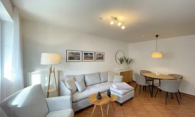 Wohnbereich mit moderner Couch mit Ottomane (1,40 m x 2,00 m), Flachbild-TV, DAB–Radio, DVD-Player, Sessel und Stehlampe