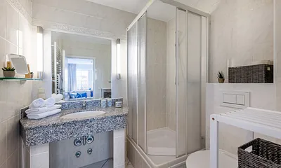 Das Badezimmer hat einen großen Waschtisch, Fön, Kosmetikspiegel  ...