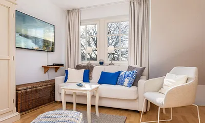 Auf dem großen internetfähigen TV können Sie NETFLIX schauen. Das Fenster hinter der Couch hat Verdunkelungsgardinen.