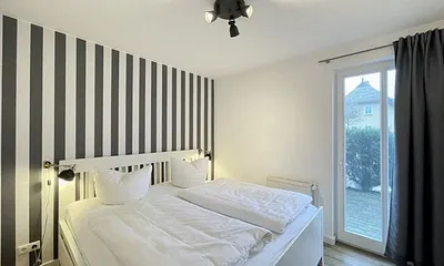 Schlafzimmer mit Doppelbett (1,80 m x 2,00 m), Wand-Nachttischlampen, verstellbare Lattenroste, Insektenschutzgitter sowie geräumiger und offener Kleiderschrank