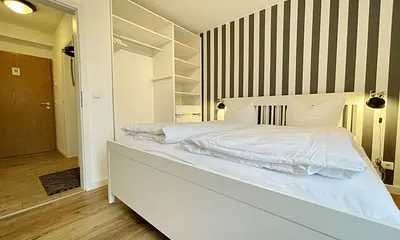 Schlafzimmer mit Doppelbett (1,80 m x 2,00 m), Wand-Nachttischlampen, verstellbare Lattenroste, Insektenschutzgitter sowie geräumiger und offener Kleiderschrank