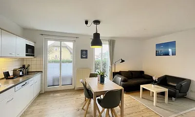 Wohnzimmer mit bequemer Leder-Schlafcouch (Aufbettungsmöglichkeit für 3. Person, 1,00 m x 2,00 m), Couchtisch, Stehlampe, Sideboard, Highboard, Sessel, 55-Zoll-Smart-TV und Bluetooth-Radio 