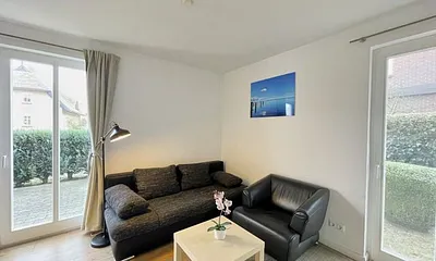 Wohnzimmer mit bequemer Leder-Schlafcouch (Aufbettungsmöglichkeit für 3. Person, 1,00 m x 2,00 m), Couchtisch, Stehlampe, Sideboard, Highboard, Sessel, 55-Zoll-Smart-TV und Bluetooth-Radio 