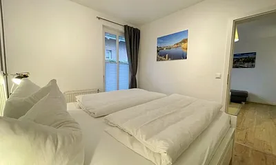 Schlafzimmer mit Doppelbett (1,80 m x 2,00 m), Wand-Nachttischlampe, verstellbare Lattenroste, Insektenschutzgitter sowie ein geräumiger und offener Kleiderschrank