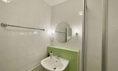 innenliegendes Badezimmer mit Eck-Dusche, Fön, WC, Ablage, beleuchteter Spiegel, Insektenschutzgitter und ein Waschplatz