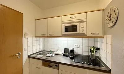 Pantry-Küche mit Induktionsherd, Kühlschrank mit Gefrierfach, Mikrowelle, Geschirrspüler, Filter-Kaffeemaschine, Nespresso-Kapselmaschine, Wasserkocher, Toaster, Messerblock sowie viele Kochutensilien
