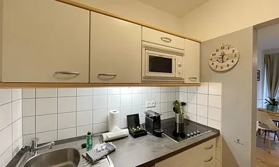 Pantry-Küche mit Induktionsherd, Kühlschrank mit Gefrierfach, Mikrowelle, Geschirrspüler, Filter-Kaffeemaschine, Nespresso-Kapselmaschine, Wasserkocher, Toaster, Messerblock sowie viele Kochutensilien