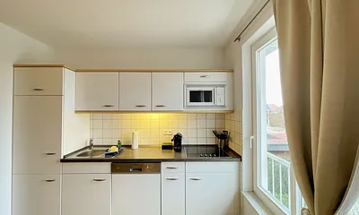 Einbauküche mit Induktionsherd, Kühlschrank mit Gefrierfach, Mikrowelle, Geschirrspüler, Filter-Kaffeemaschine, Nespresso-Kapselmaschine, Wasserkocher, Toaster, Messerblock sowie viele Kochutensilien