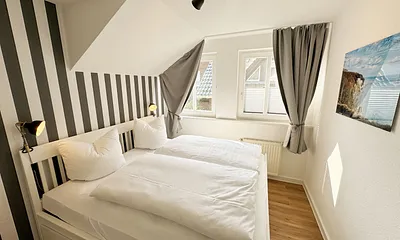 Schlafzimmer mit Doppelbett (1,60 m x 2,00 m), Wand-Nachttischlampe, verstellbare Lattenroste sowie ein geräumiger Kleiderschrank