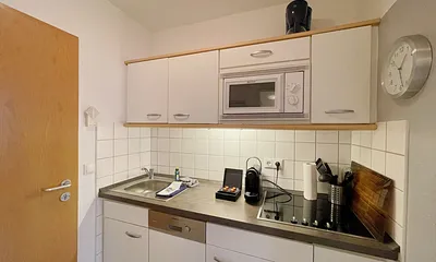 moderne Küchenzeile mit Induktionsherd, Kühlschrank mit Gefrierfach, Mikrowelle, Geschirrspüler, Filter-Kaffeemaschine, Nespresso-Kapselmaschine, Wasserkocher, Toaster & Messerblock
