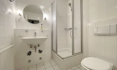 innenliegendes Badezimmer mit Eck-Dusche, Fön, WC, Ablage, beleuchteter Spiegel, Insektenschutzgitter und ein Waschplatz