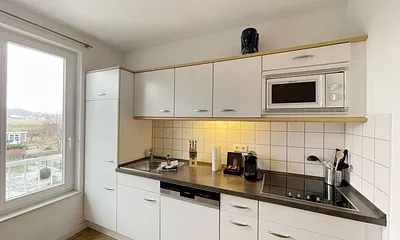 moderne Einbauküche mit Induktionsherd, Kühlschrank mit Gefrierfach, Mikrowelle, Geschirrspüler, Filter-Kaffeemaschine, Nespresso-Kapselmaschine, Wasserkocher, Toaster & Messerblock