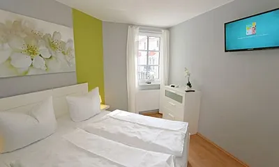 Schlafzimmer mit Doppelbett (1,60 m x 2,00 m), hochwertigen Matratzen, verstellbaren Lattenrosten, 2 Nachttischlampen, Flachbild-TV, Radiowecker und Kleiderschrank