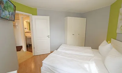 Schlafzimmer mit Doppelbett (1,60 m x 2,00 m), hochwertigen Matratzen, verstellbaren Lattenrosten, 2 Nachttischlampen, Flachbild-TV, Radiowecker und Kleiderschrank