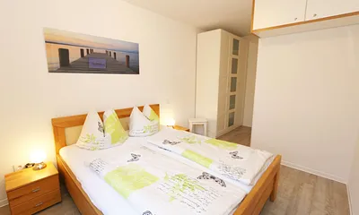 Schlafzimmer mit Doppelbett (1,80 m x 2,00 m), verstellbare Lattenroste, Nachttischkonsolen, Kleiderschrank und einem Flachbild-TV